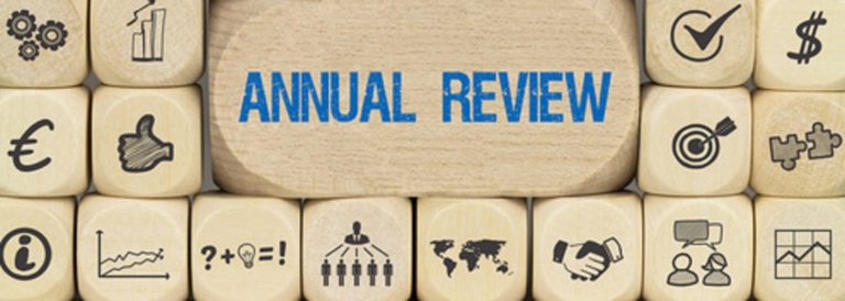 Wooden block with symbols and "Annual Review" text