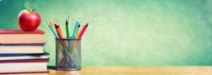 Books, a pot of pencils and a blackboard