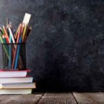 Stacked books with a pencil pot full of pencils