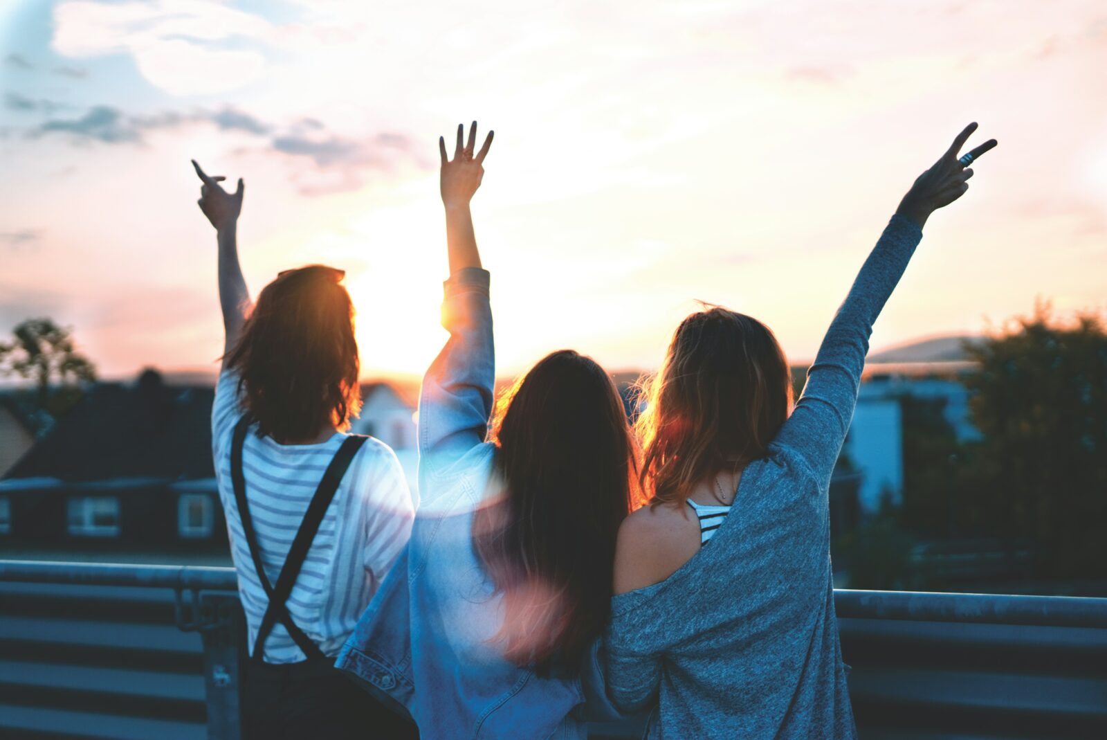 Young people with raised arms turned away from the camera